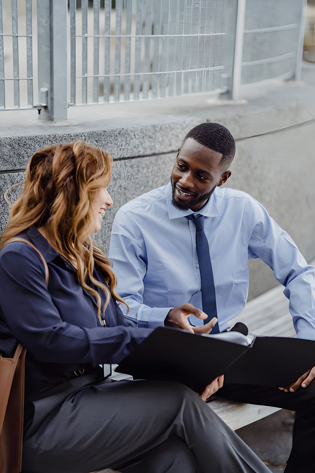 Two business professionals smiling and connecting outdoors